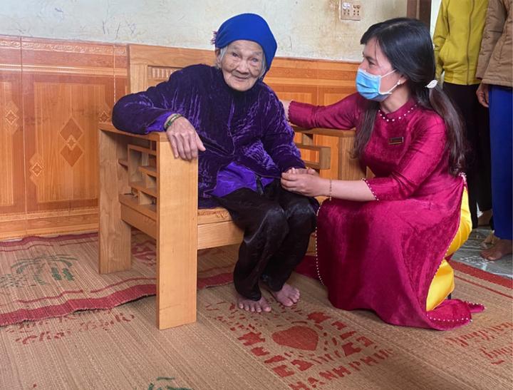 Đồng chí Dương Thị Len, Huyện ủy viên, Bí thư Đảng ủy xã thăm, chúc mừng cụ Phạm Thị Tro, đăng tho 106 tuổi
